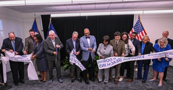 Group of people cut ribbon at an event